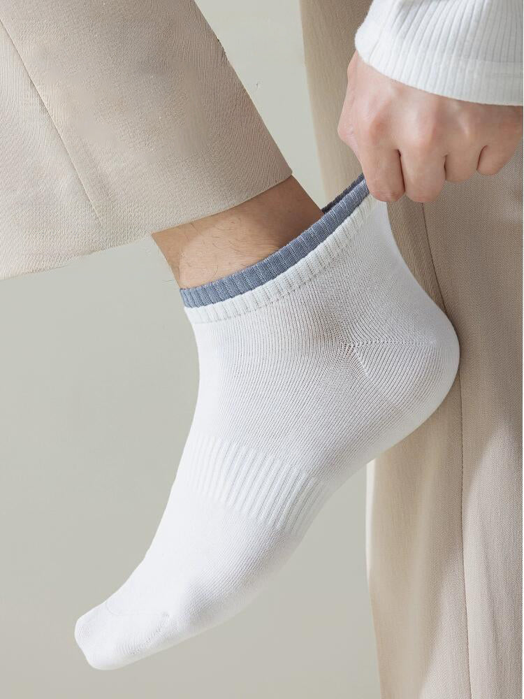 Men's ankle-length white cotton sock with grey trim, close-up, casual wear