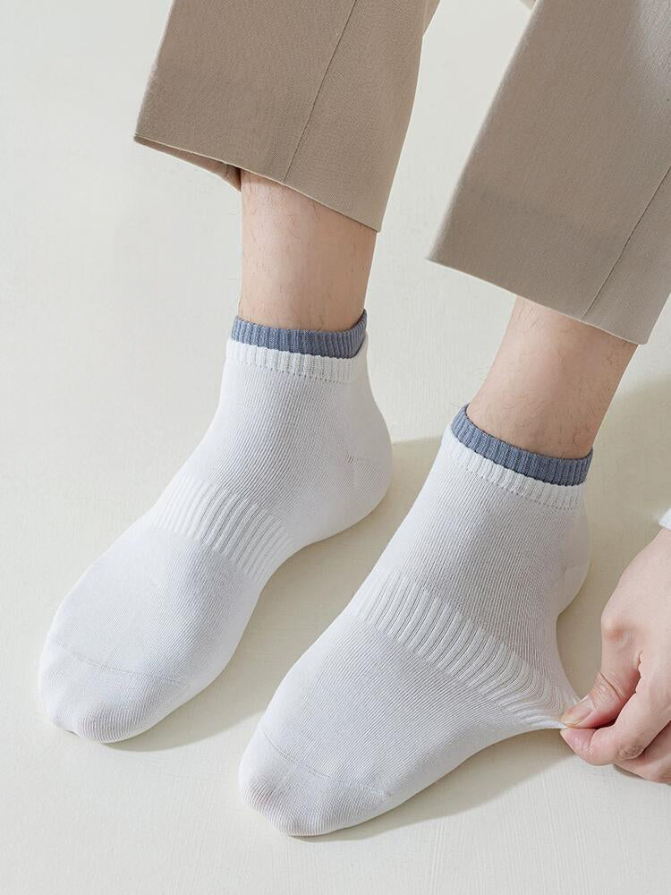 Men's white ankle socks with ribbed texture and grey trim, worn with beige pants