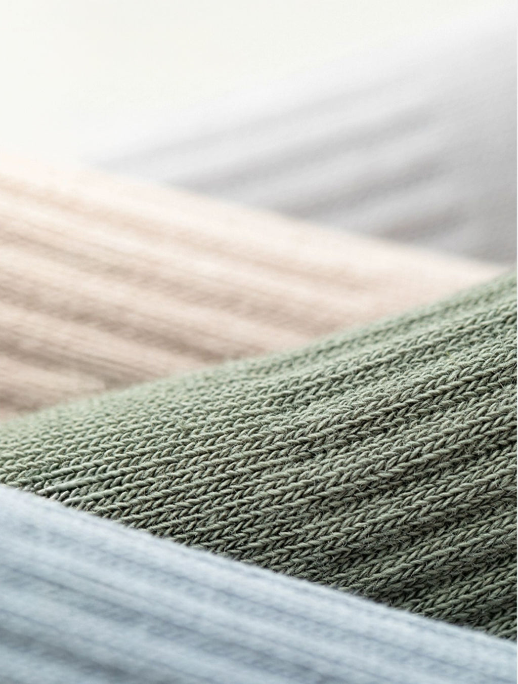 close-up of ribbed cotton knit fabric in beige, green, and grey for men's t-shirts